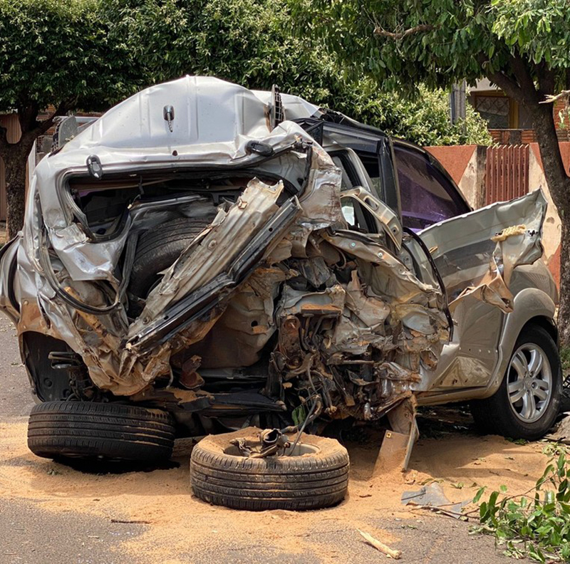 Carro fica destruído após acidente com caminhão carregado com toras