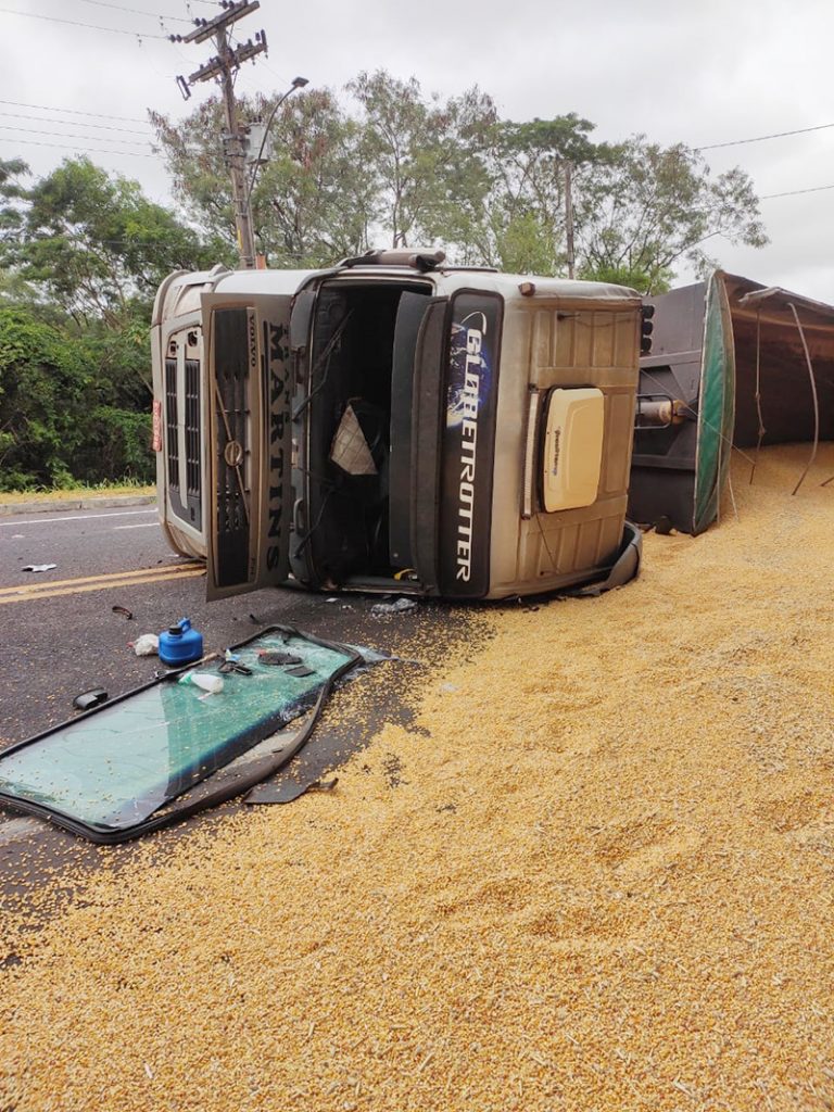 Carreta carregada de grãos tomba e motorista é socorrido pelo Corpo de Bombeiros