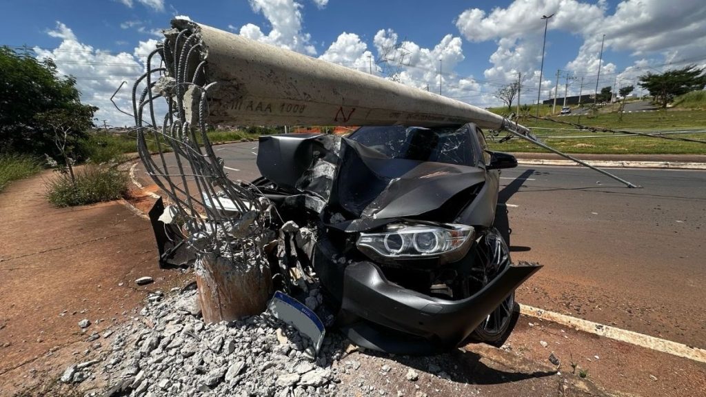 Motorista perde o controle de BMW, derrubando poste e destruindo o veículo