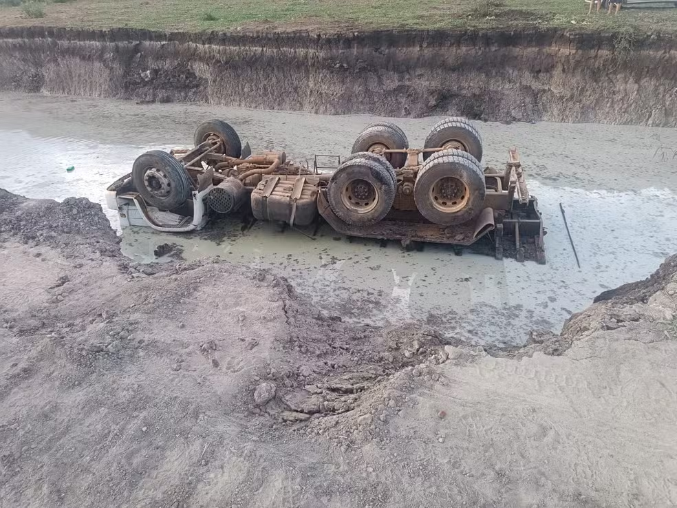 Motorista morre após caminhão tombar em barranco e cair dentro de lagoa
